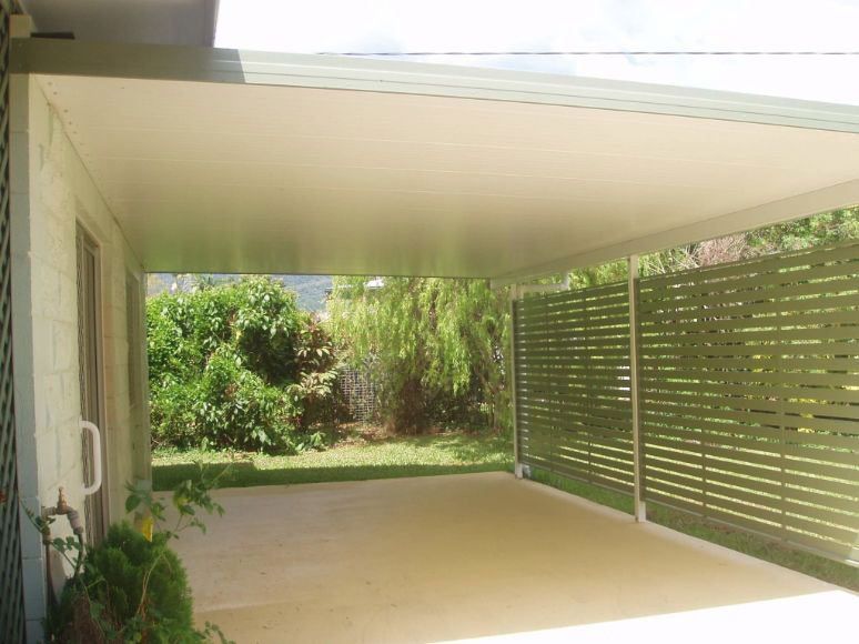 A Carport With A Wooden Fence In The Backyard Of A House — Omni Builders In Bungalow, QLD