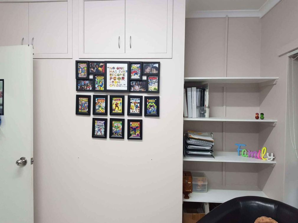 A Room With A Lot Of Pictures On The Wall And A Shelf With The Word Family On It — Omni Builders In Bungalow, QLD