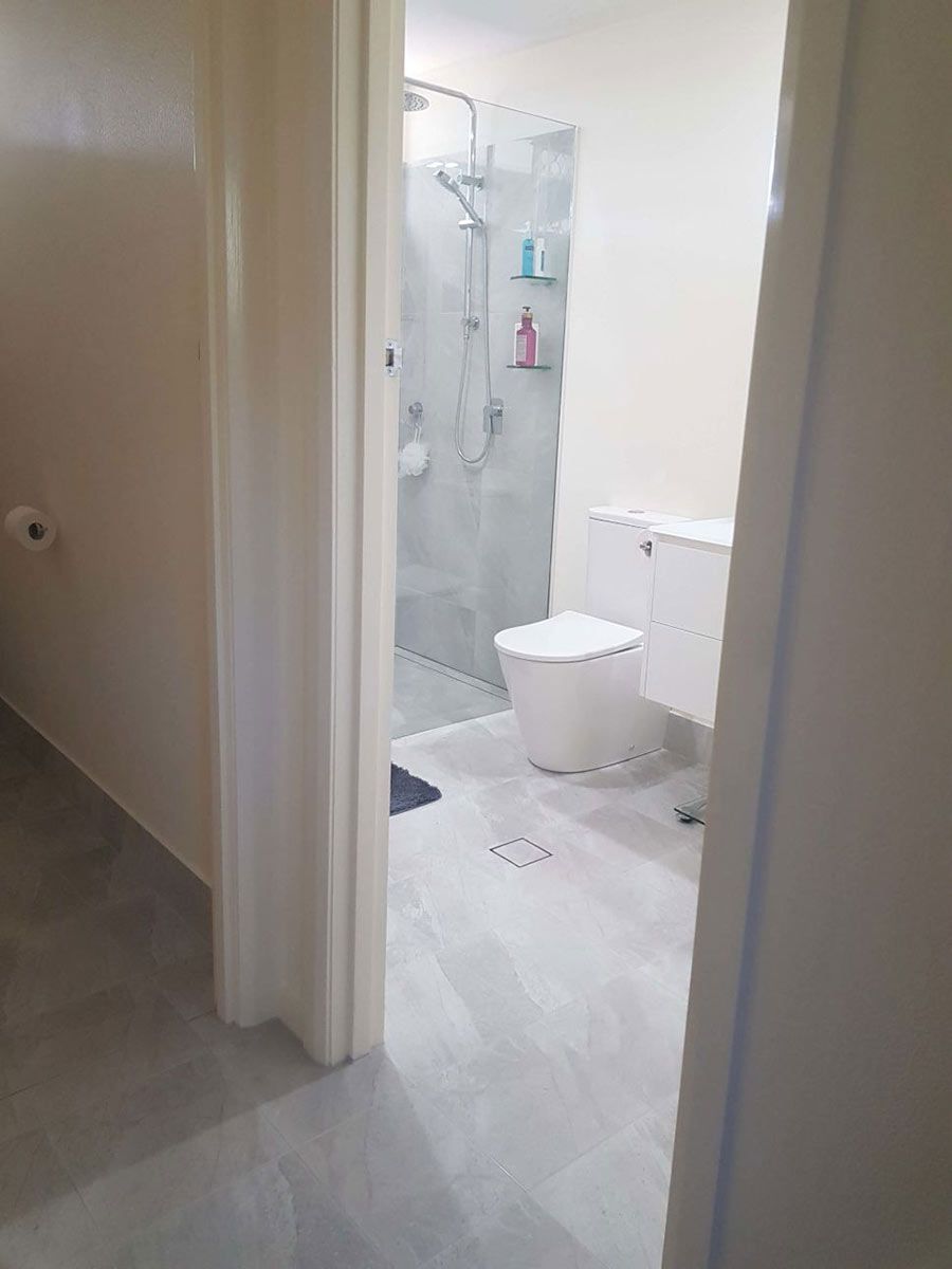 A Bathroom With A Toilet And A Walk In Shower — Omni Builders In Bungalow, QLD