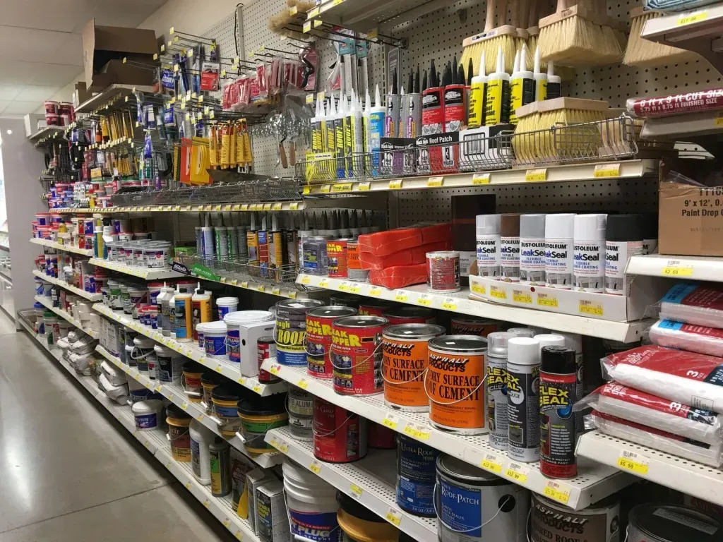 Shelves stocked with paint cans, brushes, and other hardware store supplies.