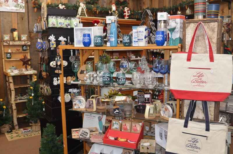 A gift shop interior with shelves displaying various items like glassware, totes, and ornaments.