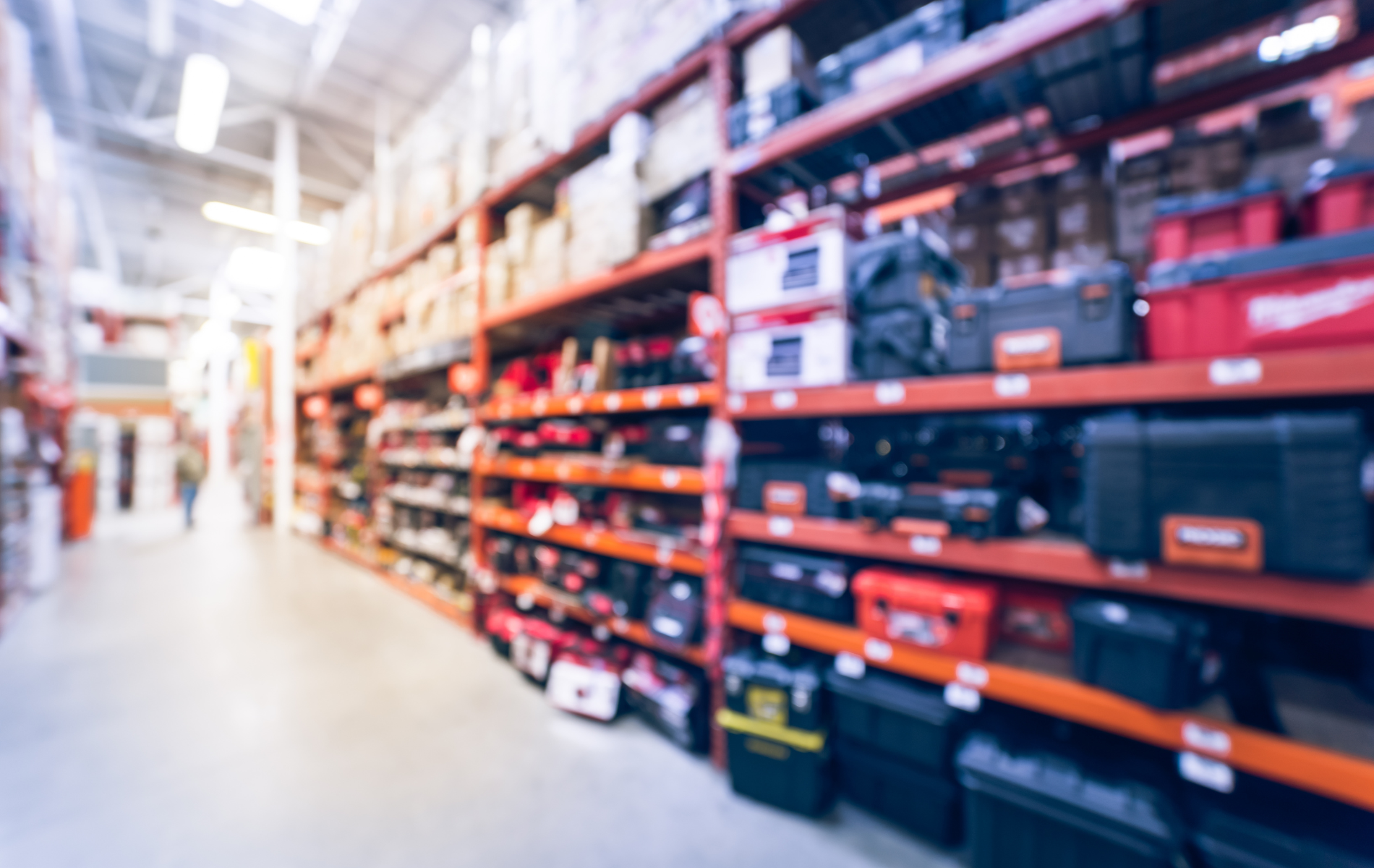 Hardware store aisle with shelves filled with tools and boxes.
