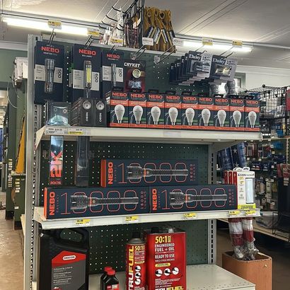 Shelves in a store filled with packaged lighting products, including flashlights and light bulbs.
