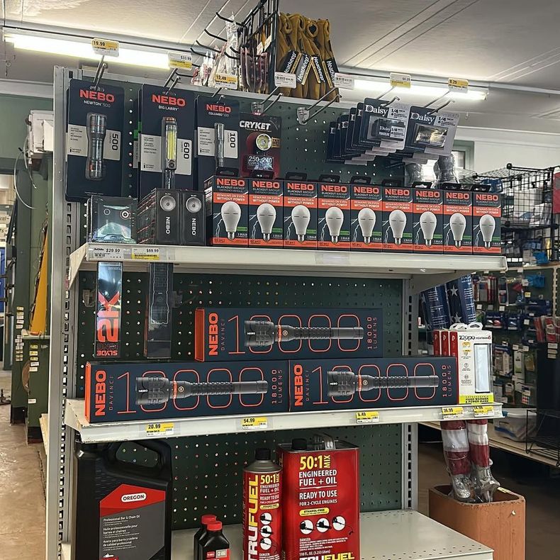 Shelves in a store filled with packaged lighting products, including flashlights and light bulbs.