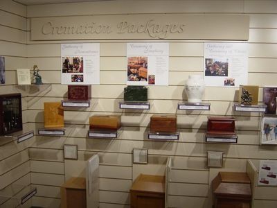 Display of cremation urns and package information in a funeral home setting.
