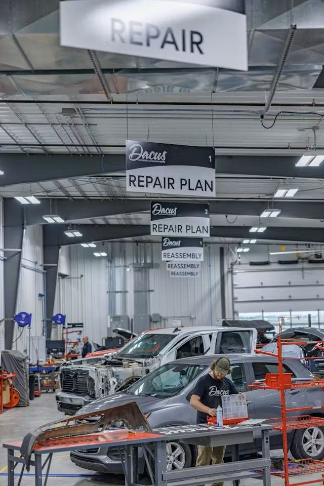 A red parts cart with a sign on it in the shop.