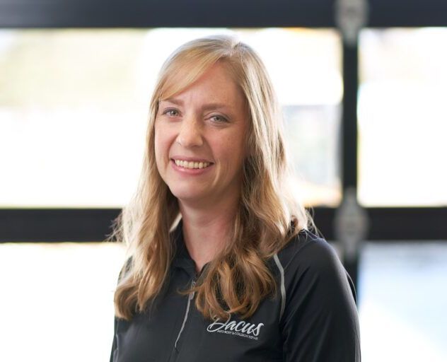 A woman wearing a black shirt with the word Dacus on it