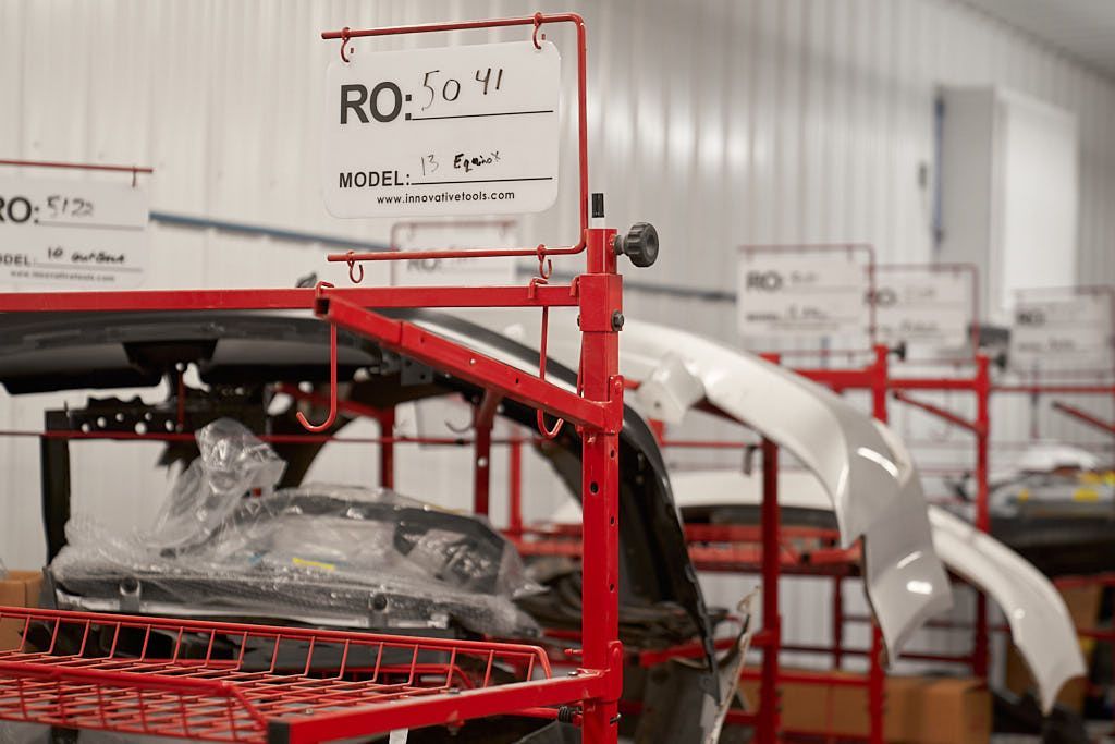 Red shelving unit holding car parts, with white sign displaying 