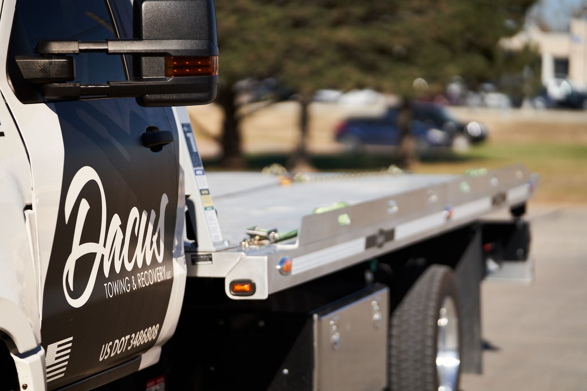Tow truck pulling a semi-truck out of the snow on a snowy road.