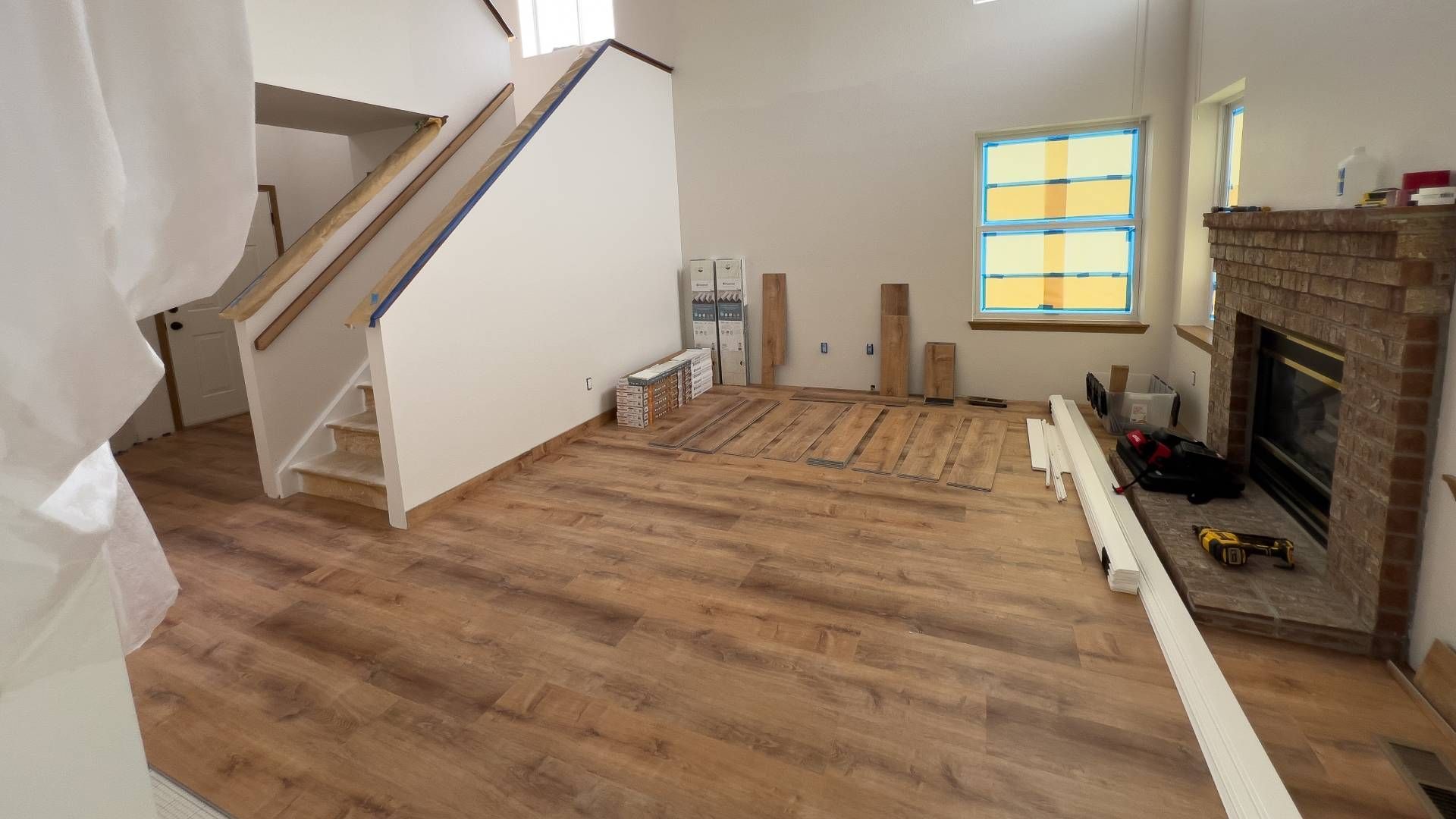A living room with hardwood floors and a fireplace under construction.