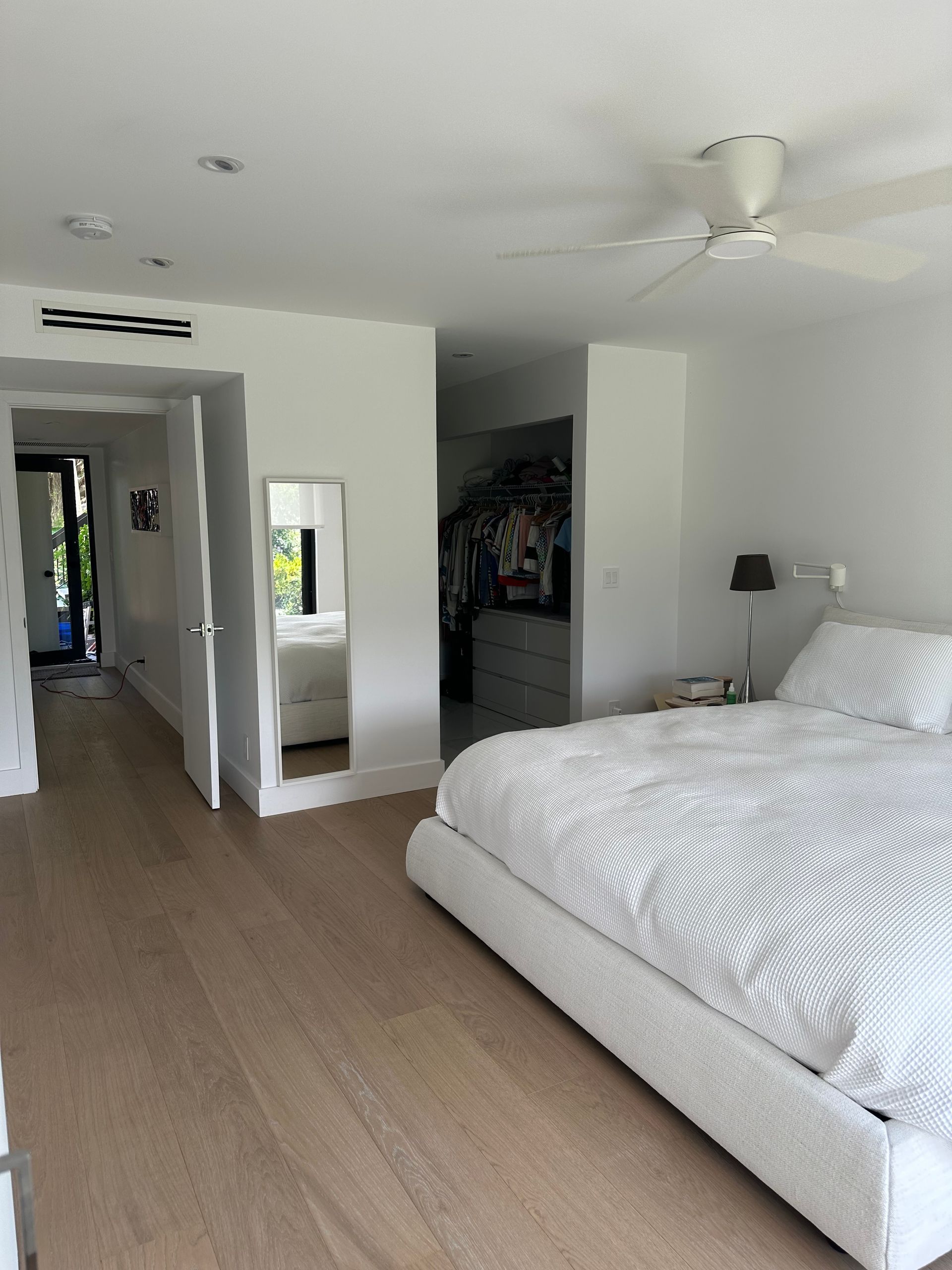 A bedroom with a large bed and a ceiling fan