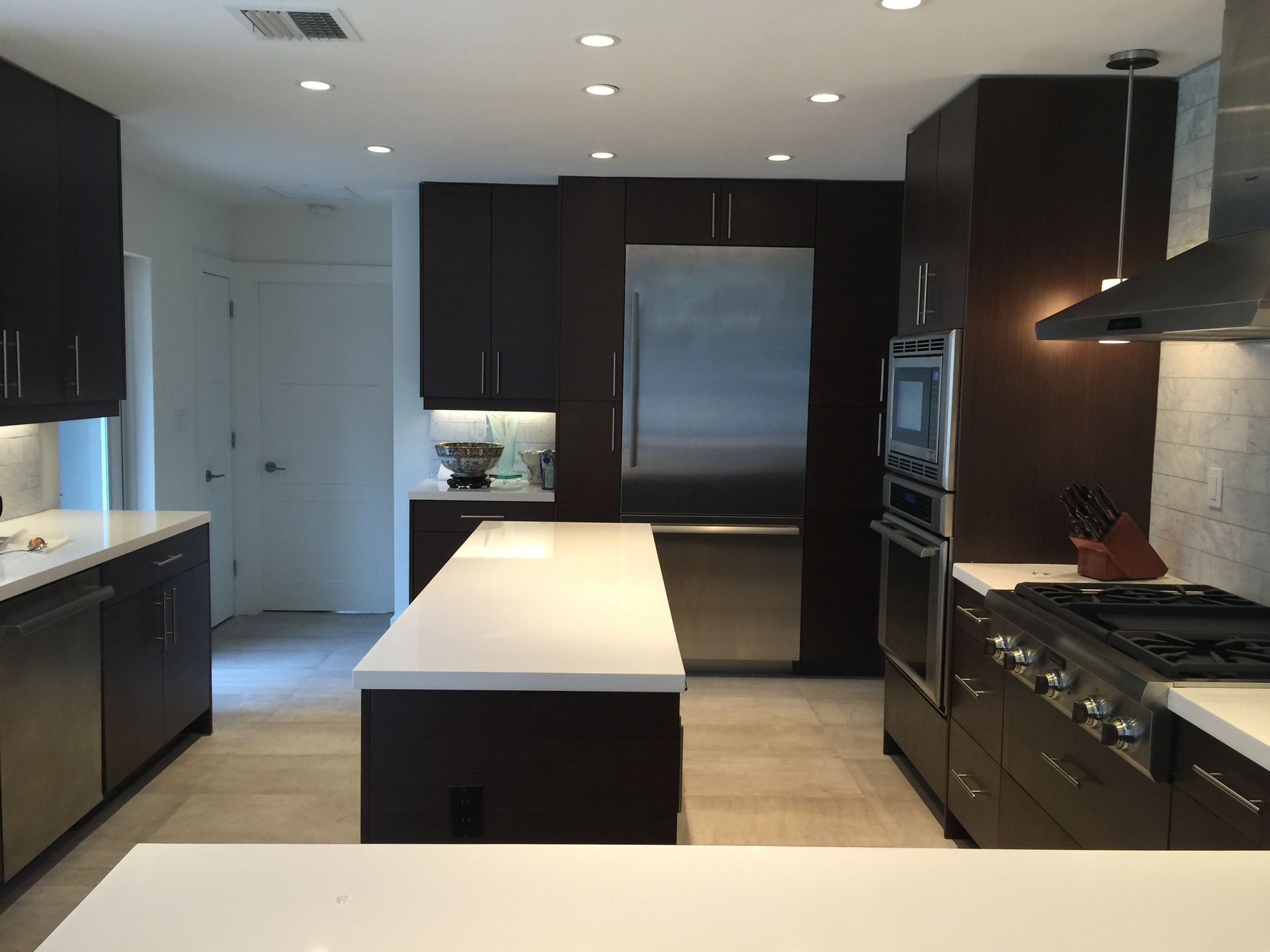A kitchen with stainless steel appliances and white counter tops