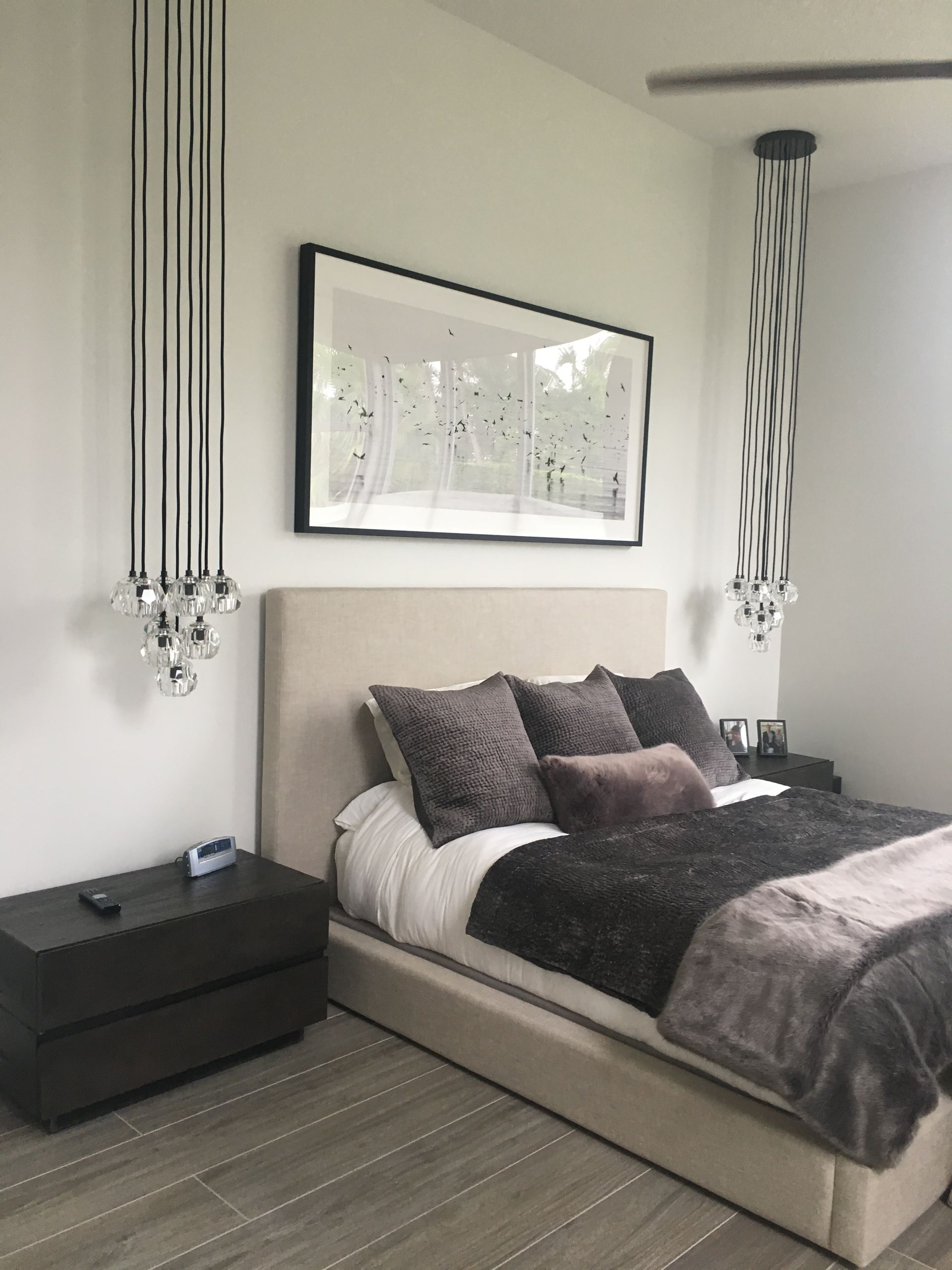 A bedroom with a large bed and a picture on the wall above it