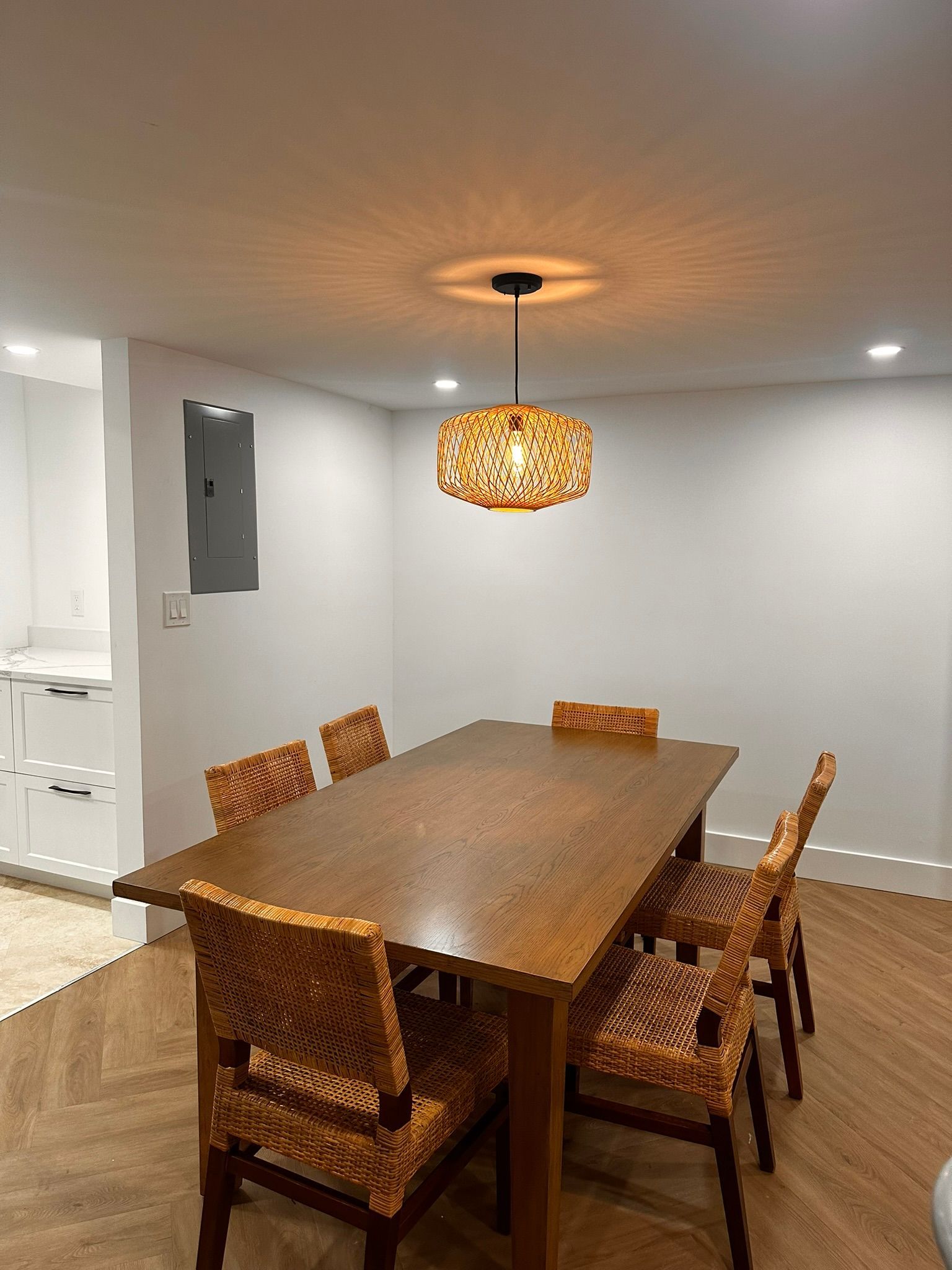 A dining room with a table and chairs and a chandelier hanging from the ceiling.