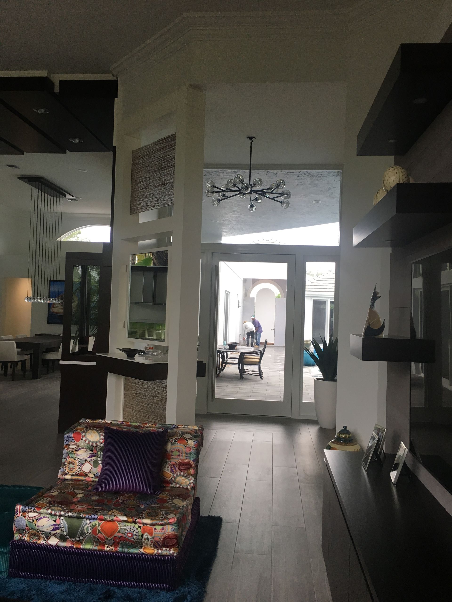 A living room with a colorful chair and a blue rug