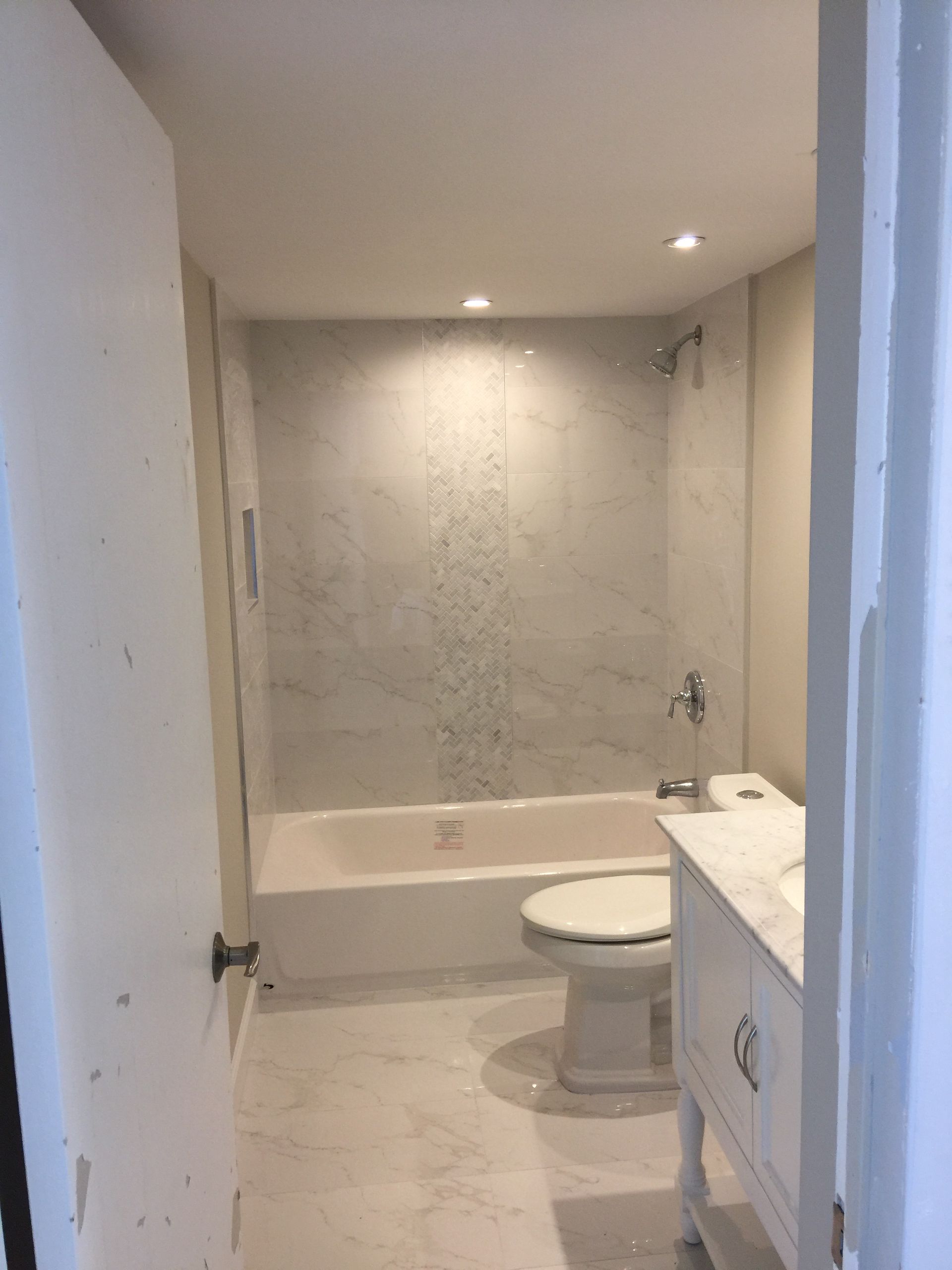 A bathroom with a toilet , sink , bathtub and shower.