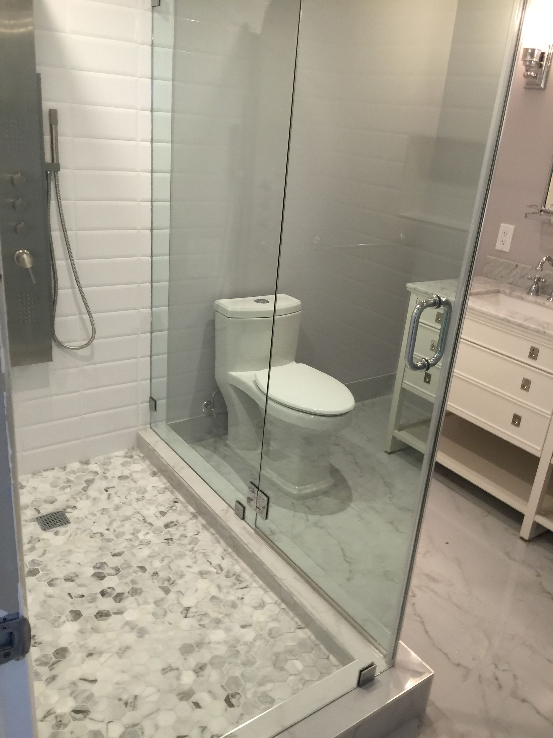 A bathroom with a toilet , sink and shower.