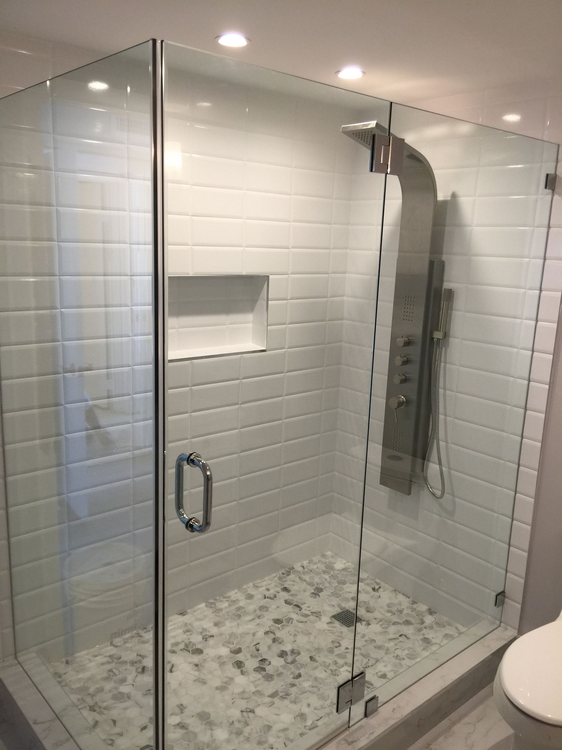 A bathroom with a walk in shower and a toilet.