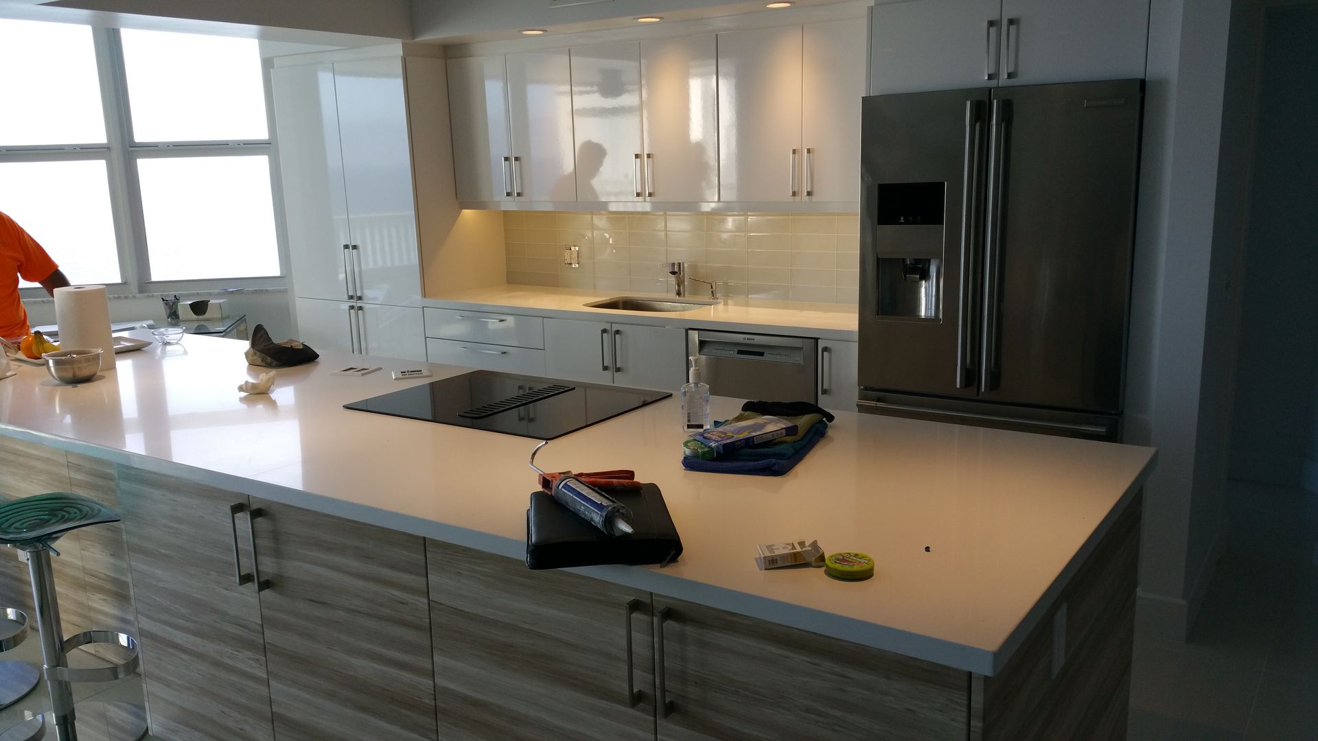 A kitchen with white cabinets and a stainless steel refrigerator