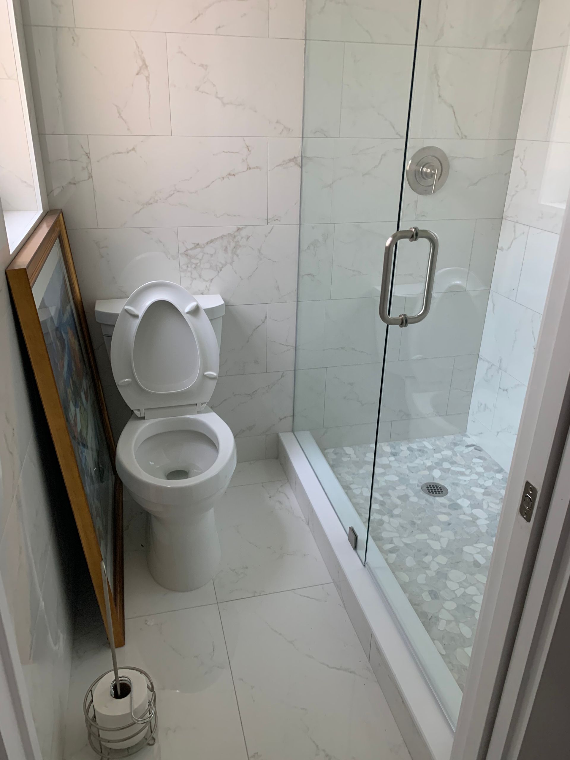 A bathroom with a toilet and a shower stall.