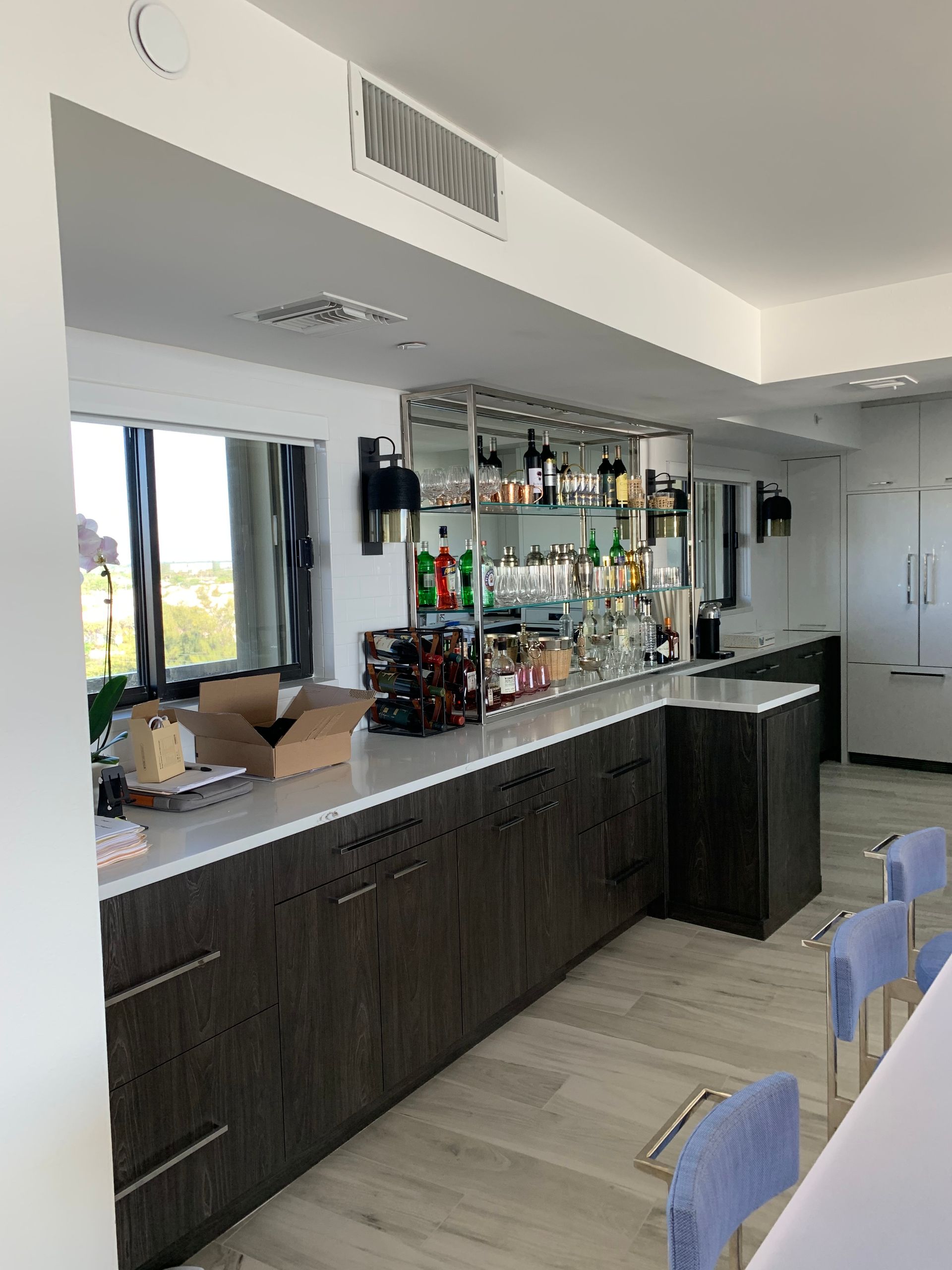 A kitchen with a long counter and a bar.