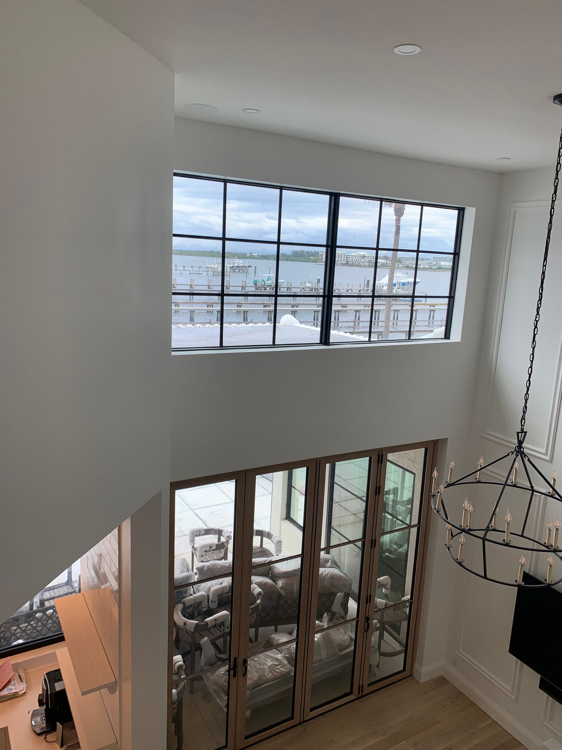 A living room with a lot of windows and a chandelier.