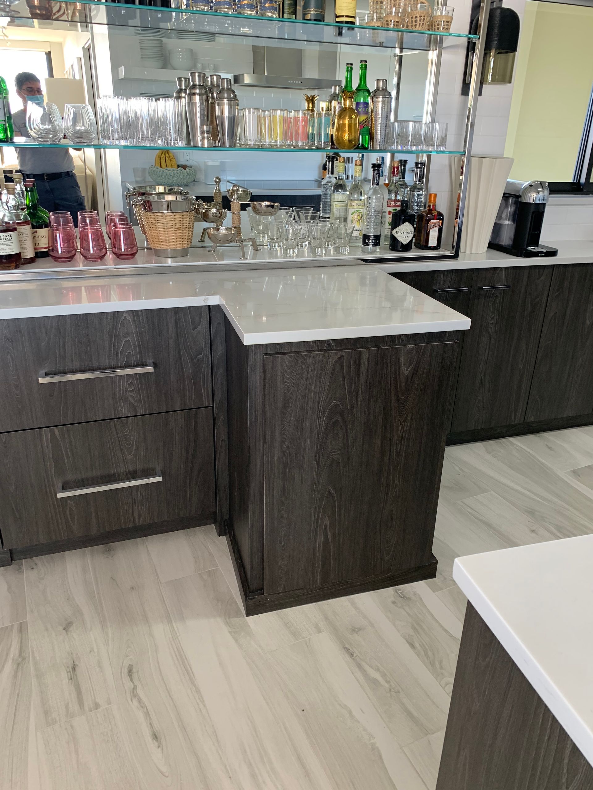 A kitchen with lots of bottles and glasses on the counter