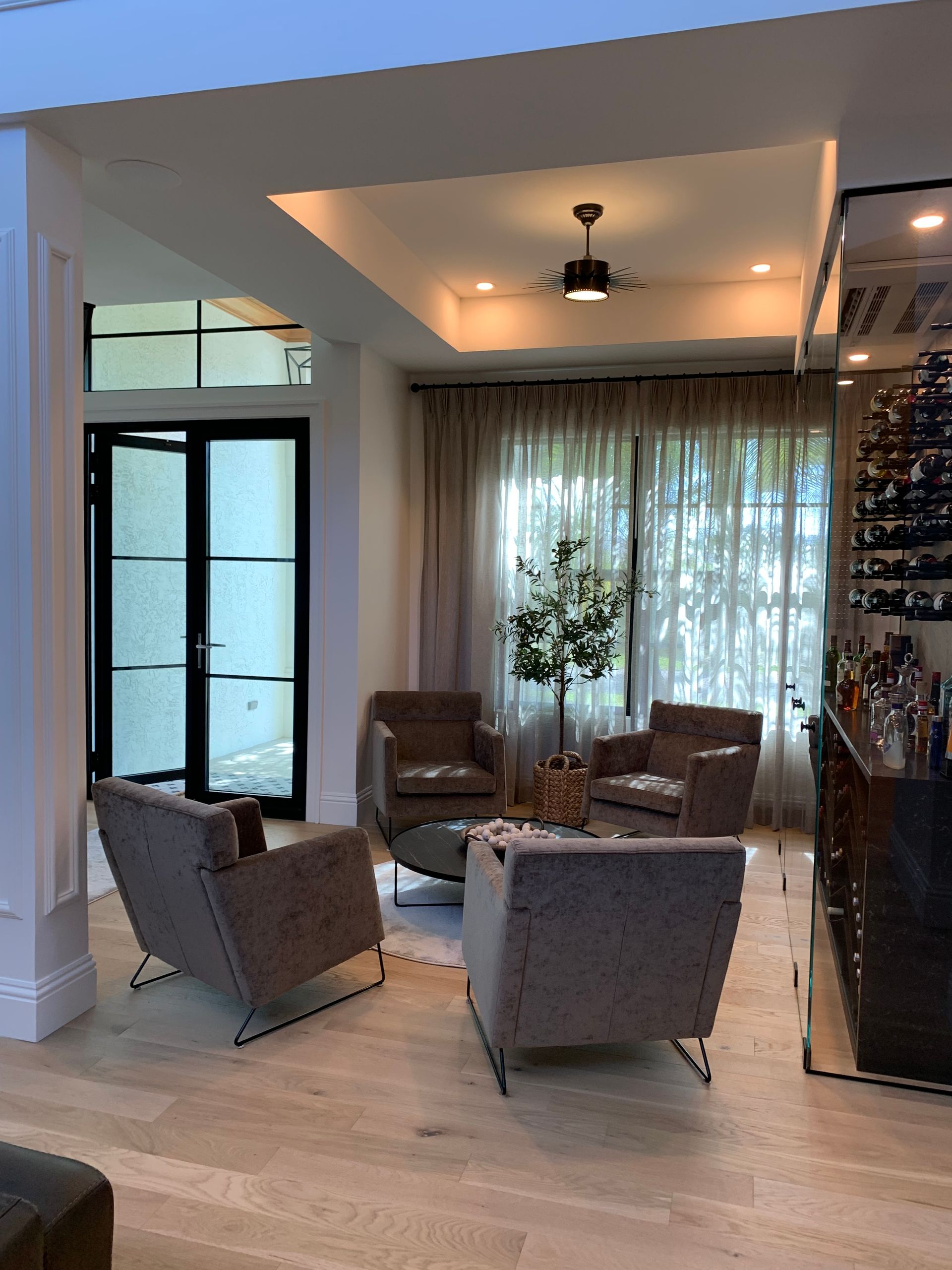 A living room with chairs , a table and a ceiling fan