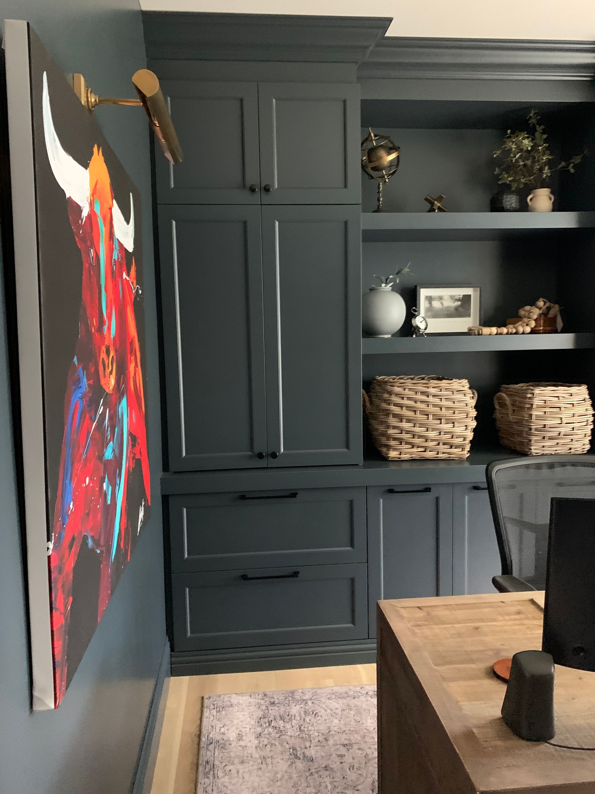 A room with a painting of a bull on the wall.