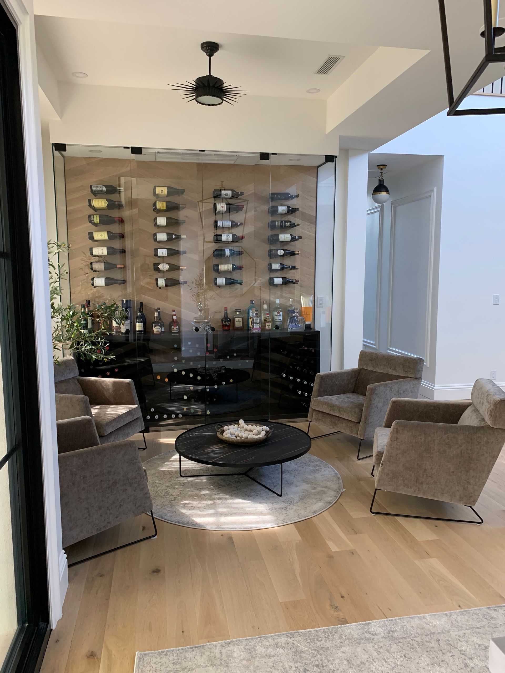 A living room with a table , chairs , and a wine rack.
