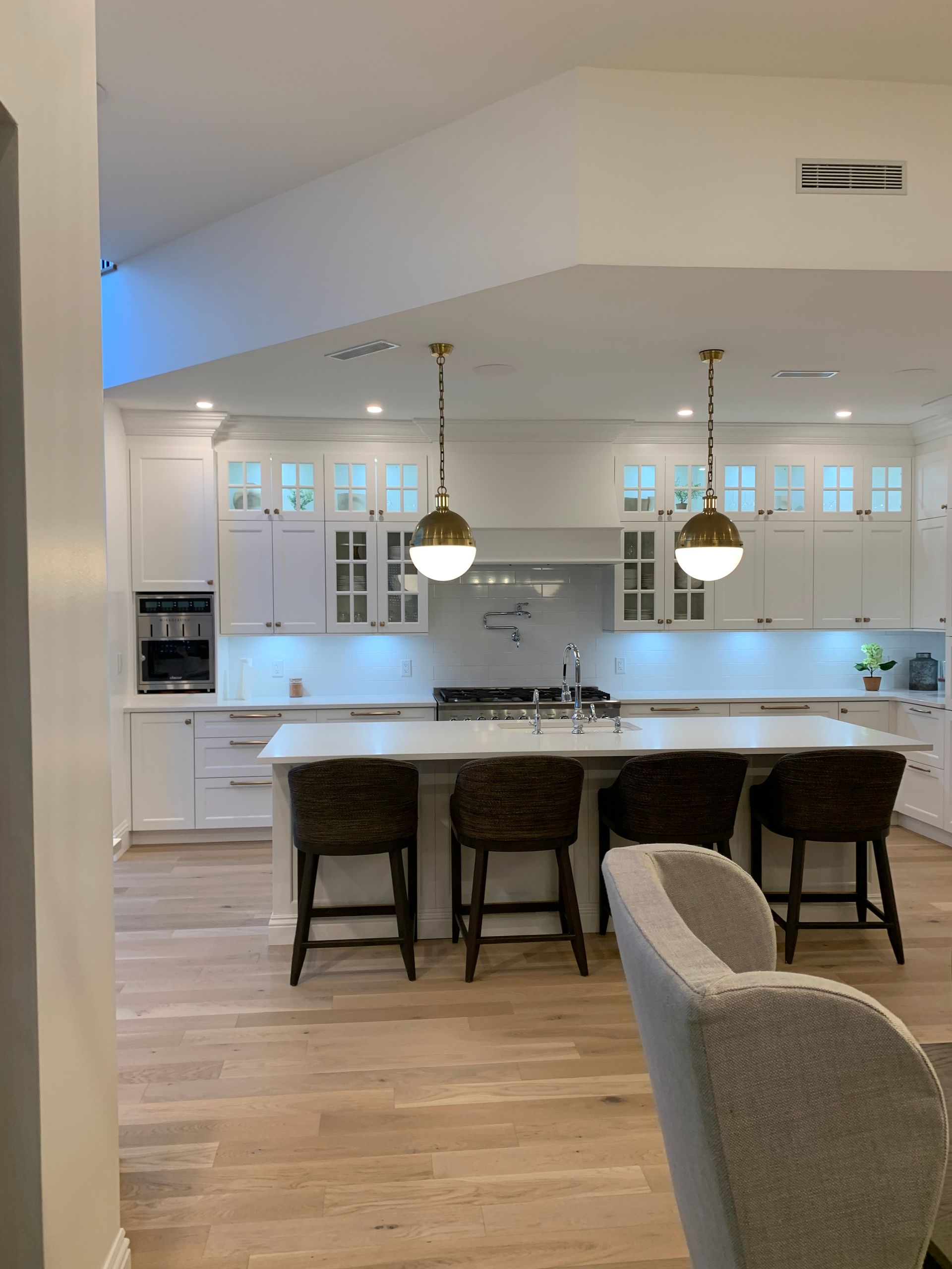 A kitchen with a large island and chairs in it