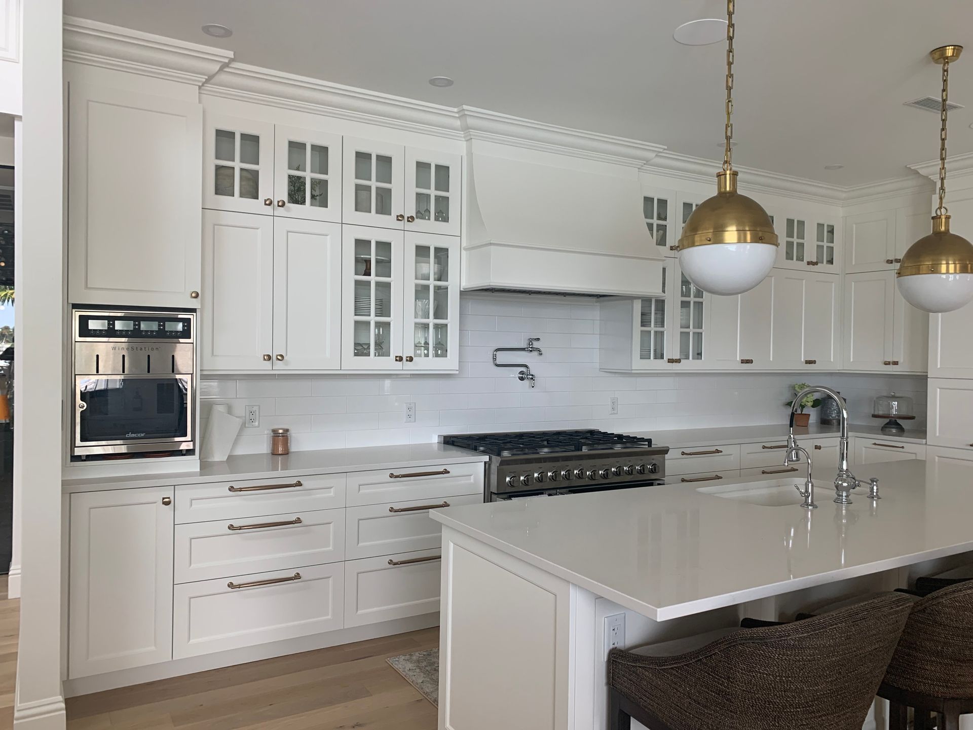 A kitchen with white cabinets , stainless steel appliances , and a large island.