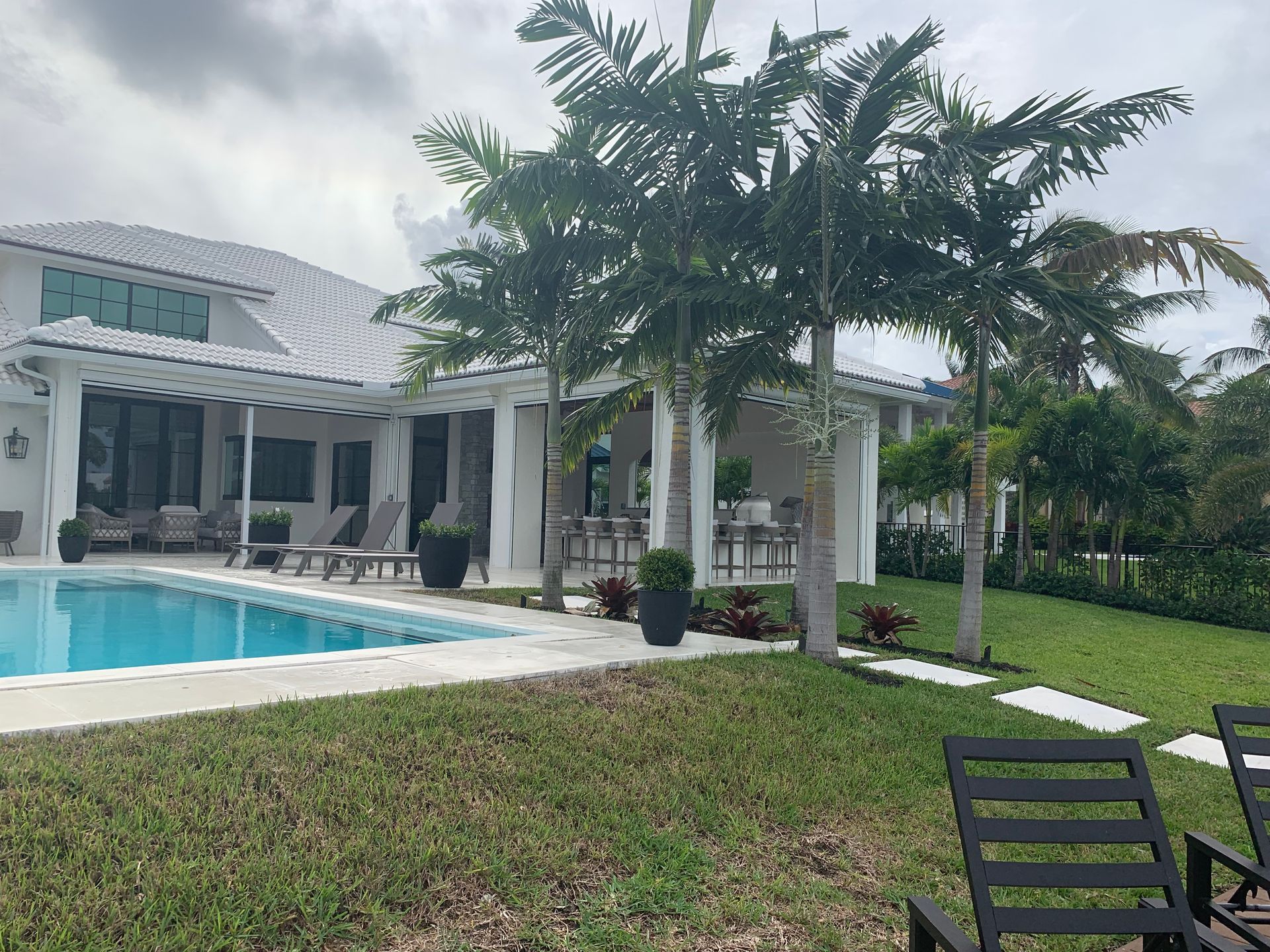 There is a large swimming pool in the backyard of a house.