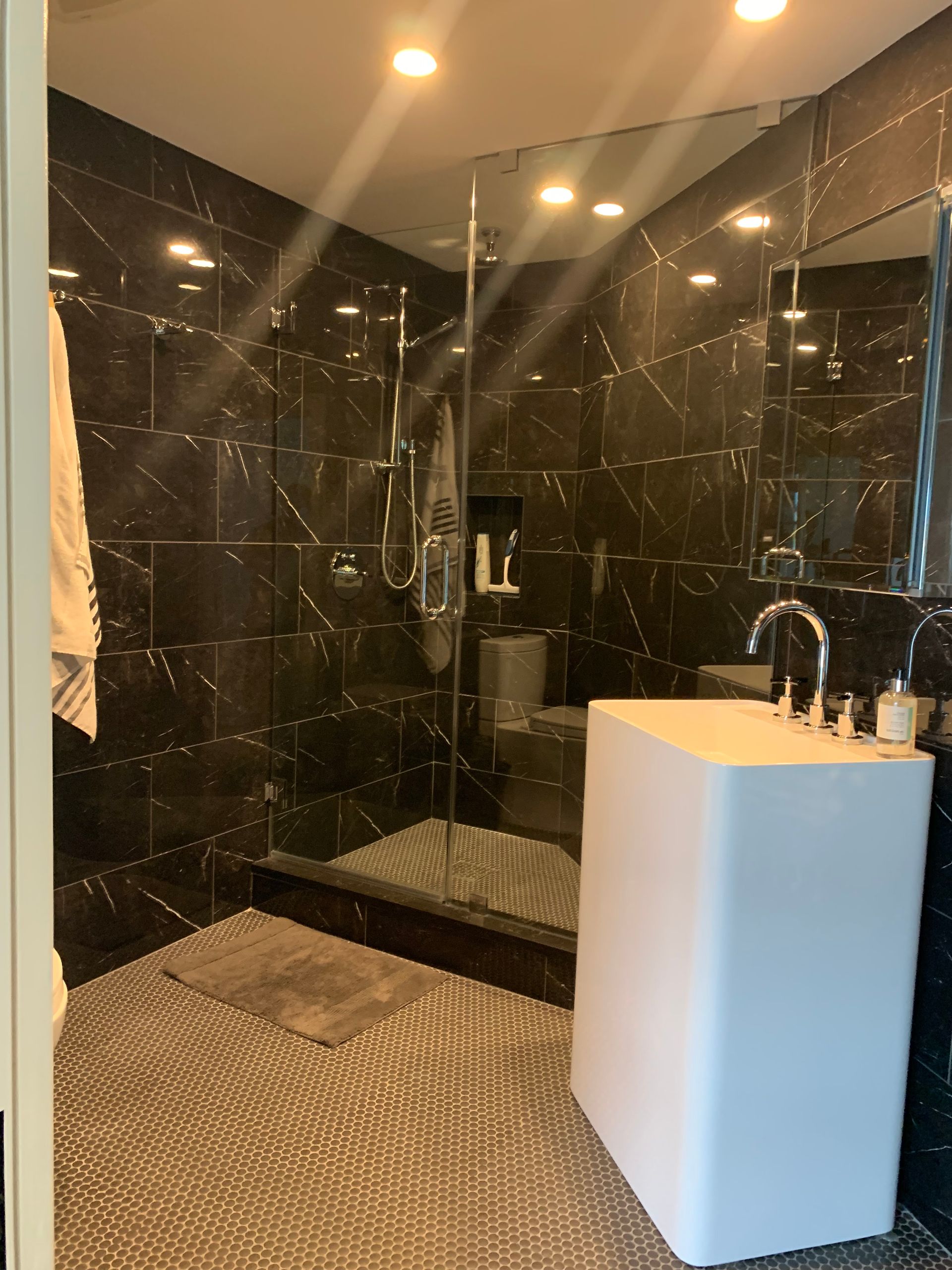 A bathroom with black tiles and a white sink