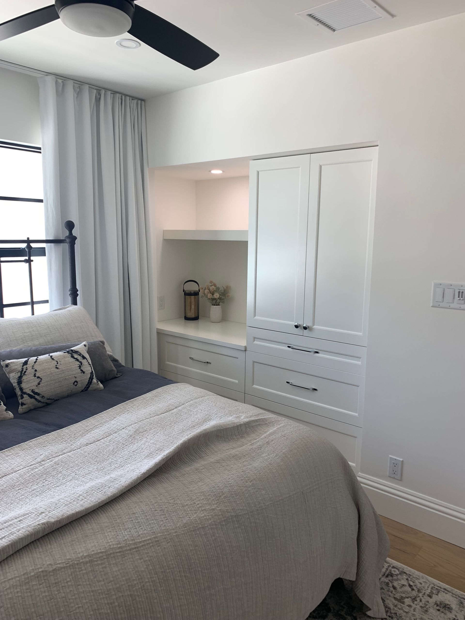 A bedroom with a bed and a ceiling fan