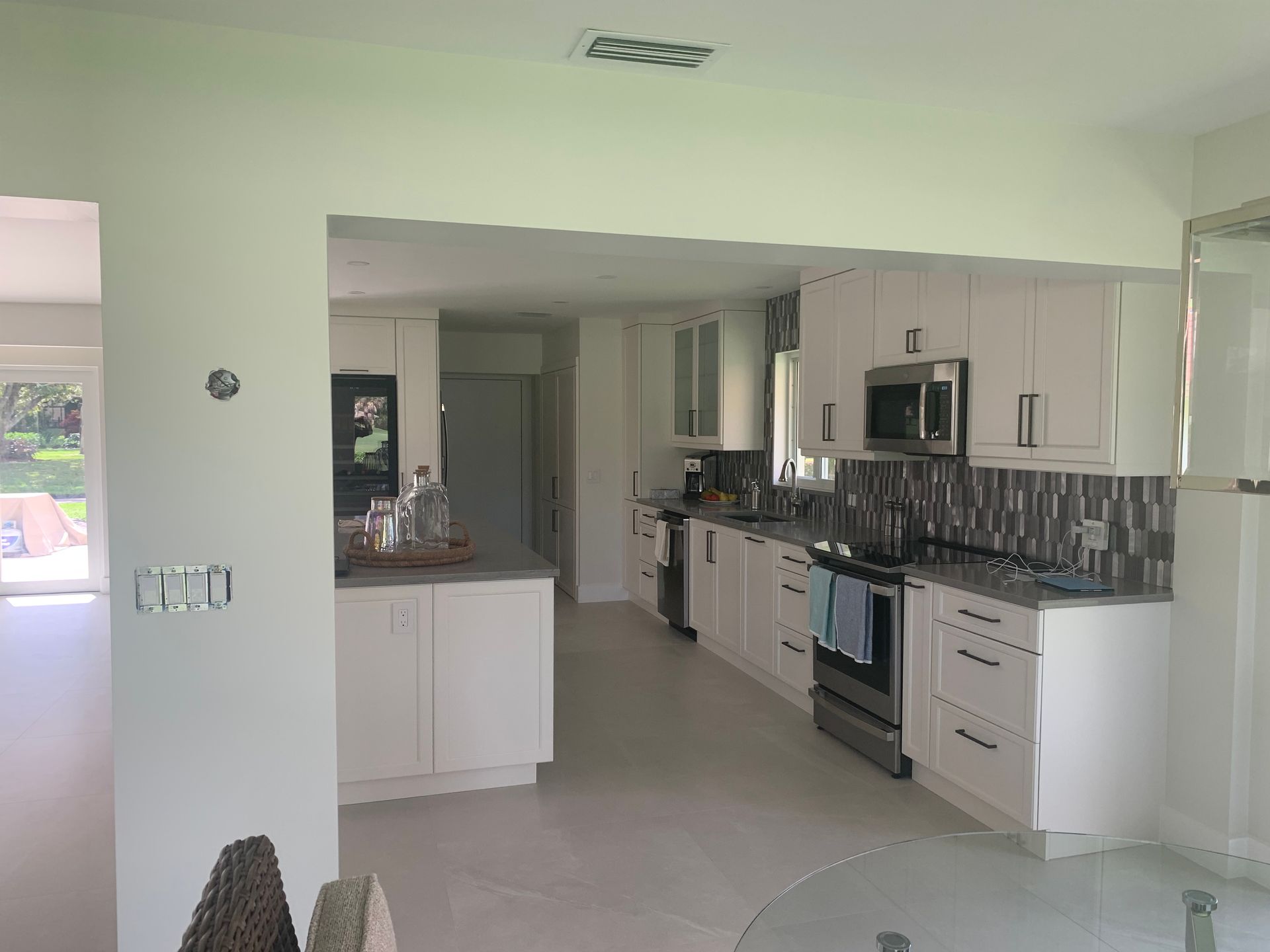 A kitchen with white cabinets and stainless steel appliances.