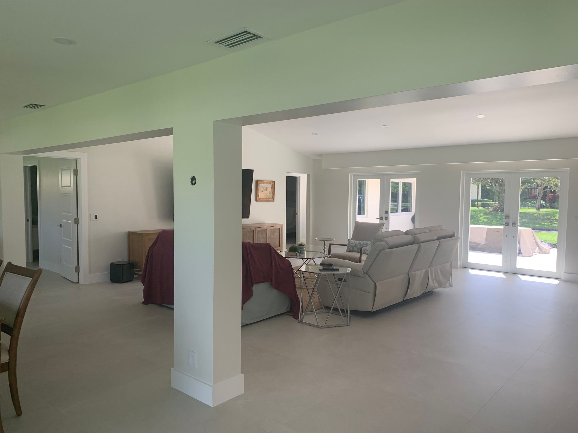A living room with a couch , chairs , and sliding glass doors.