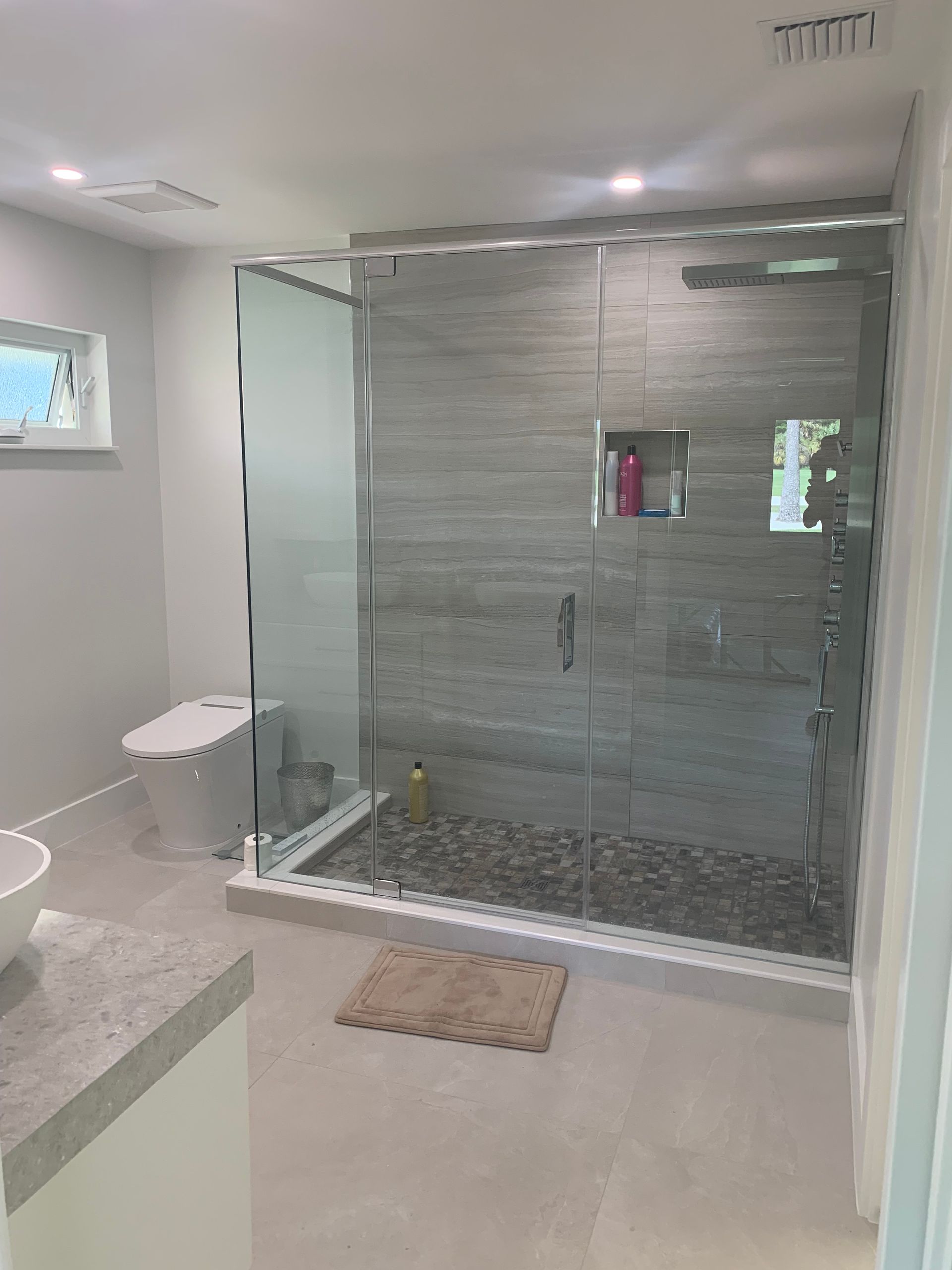 A bathroom with a walk in shower and a toilet.