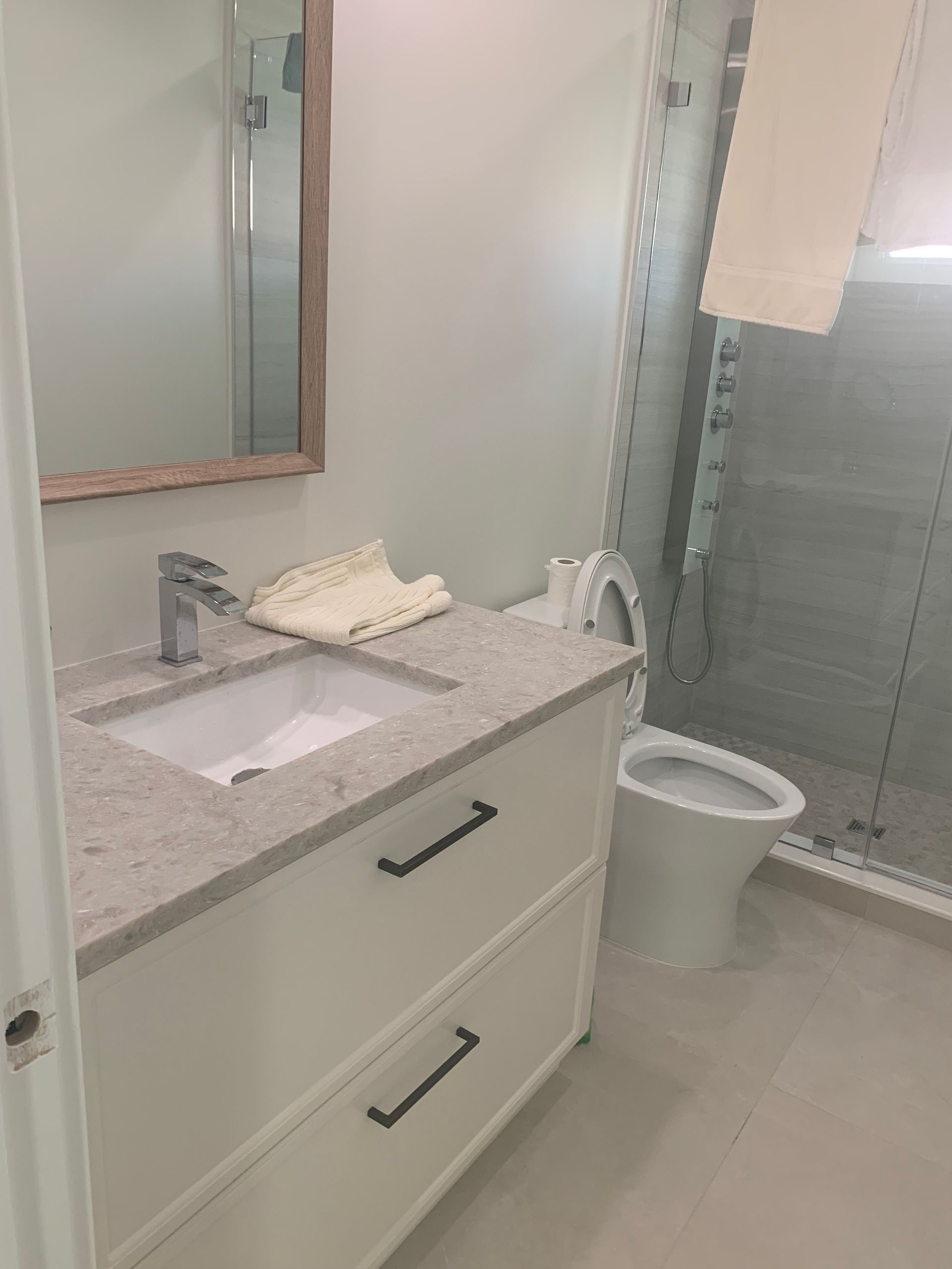 A bathroom with a sink , toilet and mirror.