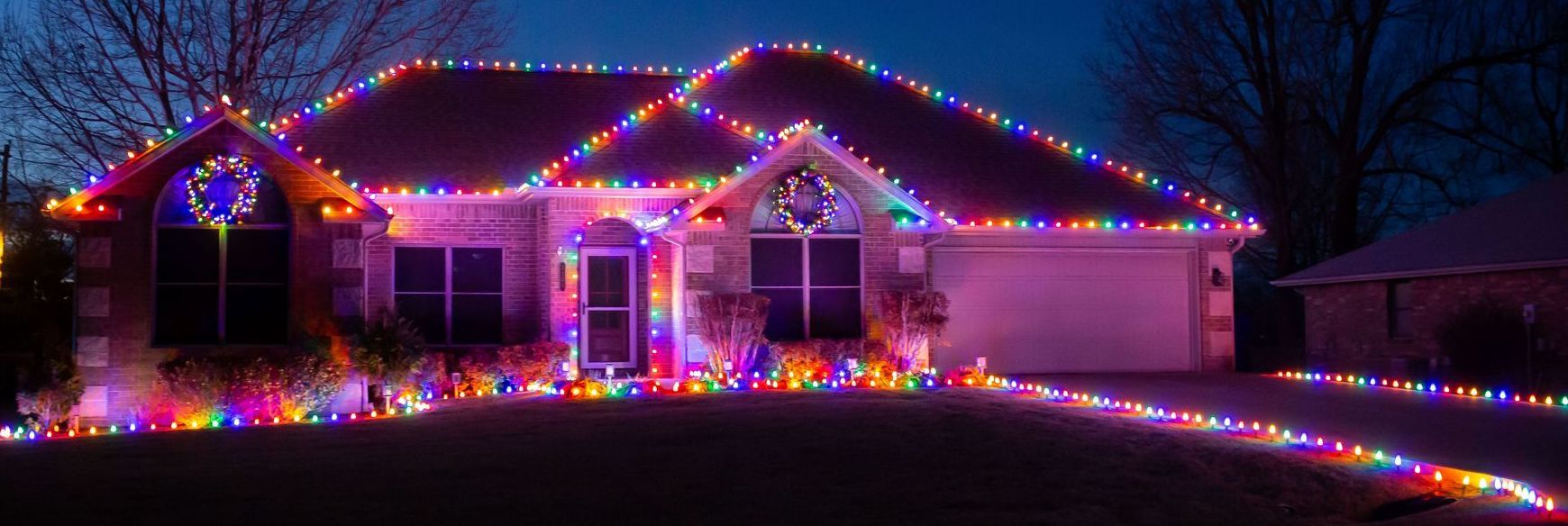 A house is decorated with lots of christmas lights at night.