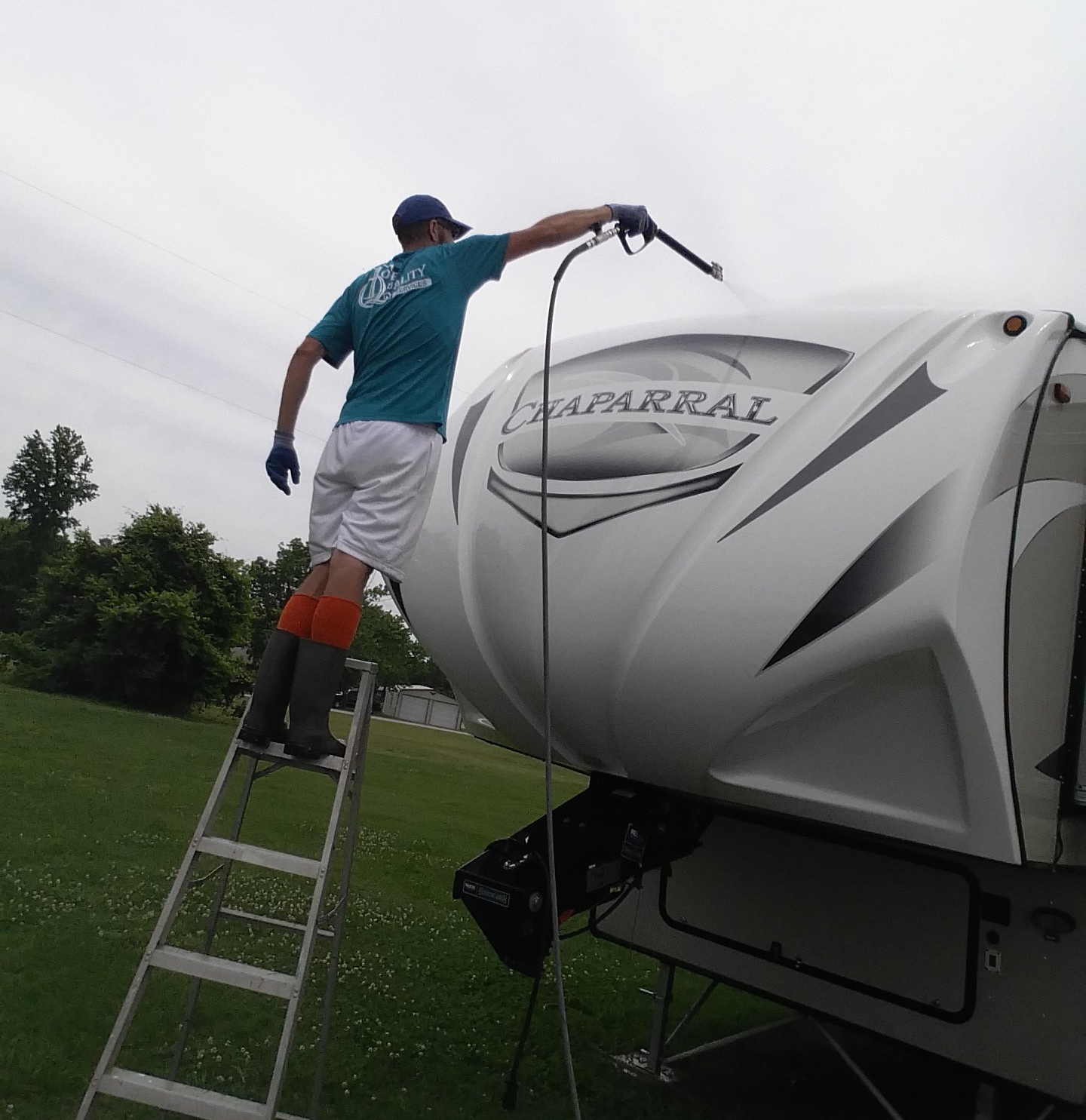 A man standing on a ladder next to a rv that says naparrax