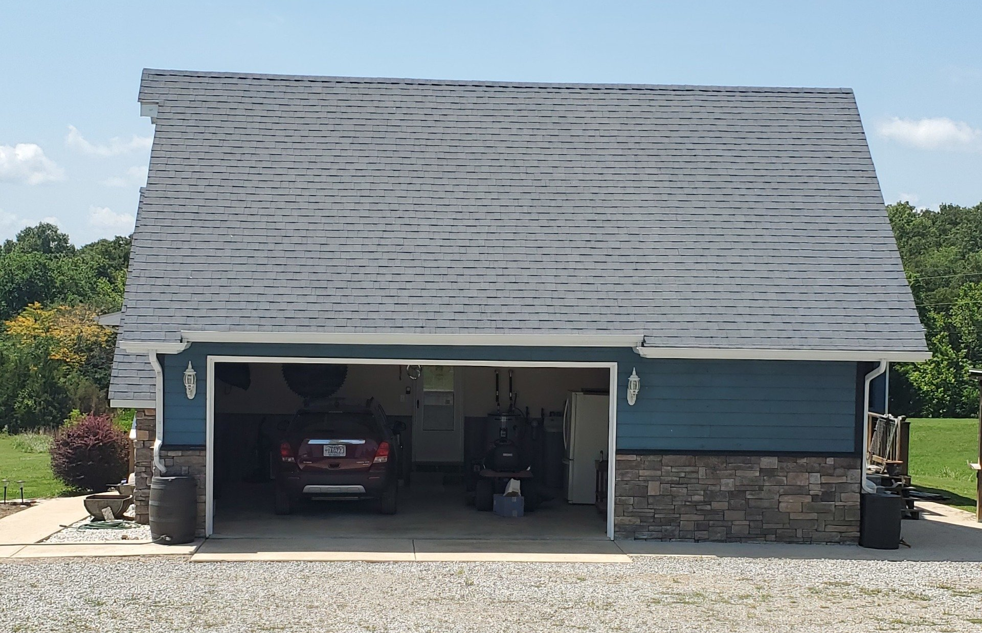 A car is parked in a garage with the door open