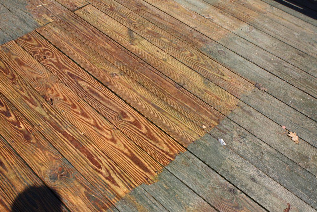 A wooden deck with a few pieces of wood missing