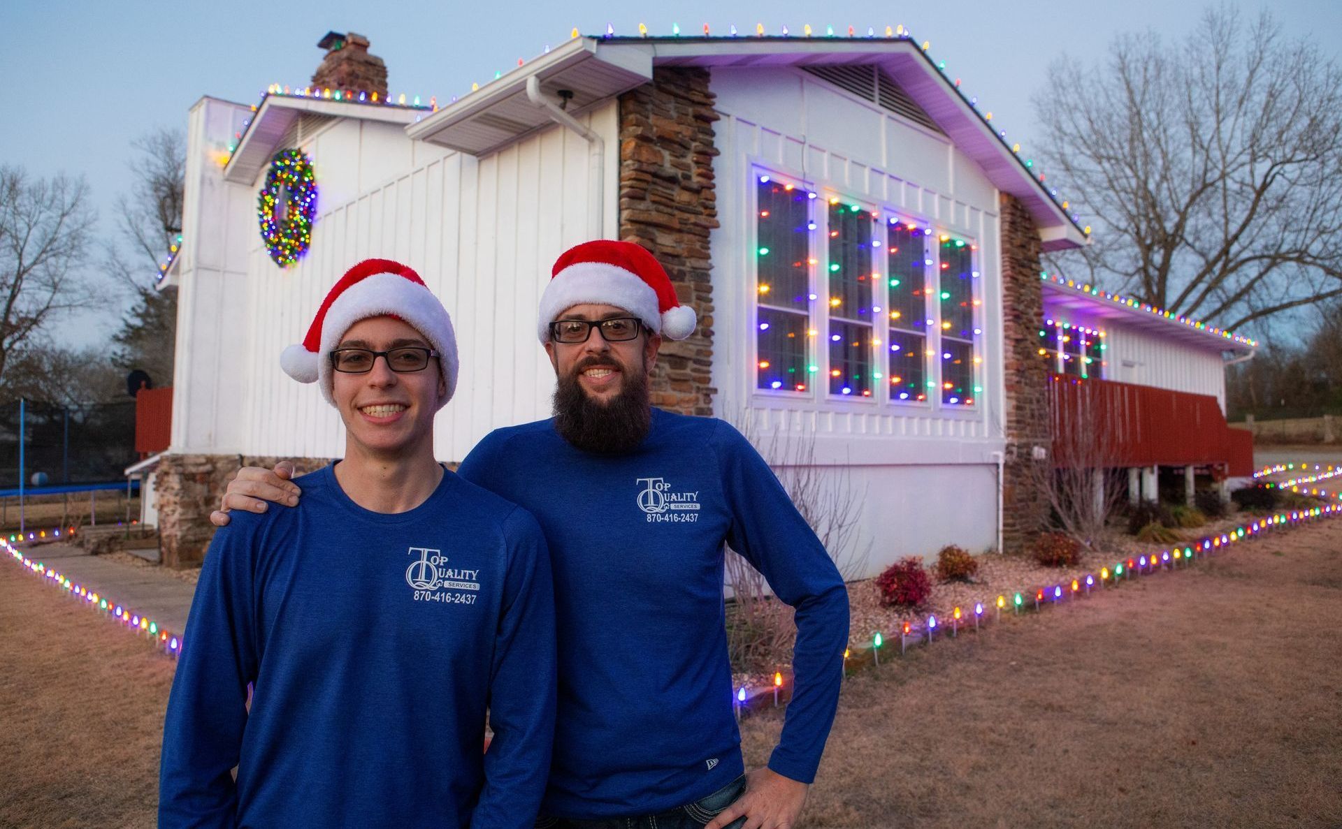 A man is standing in front of a van that says top quality