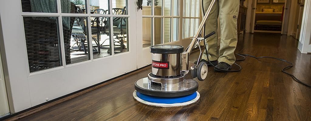 Professional Floor cleaning machine in action buffing clean a hardwood floor.