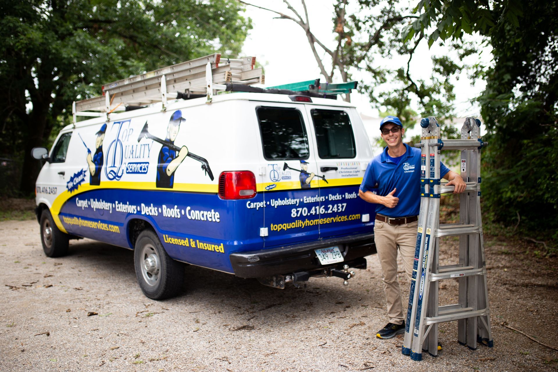 A man is standing next to a ladder in front of a van.