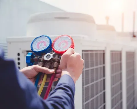 HVAC technician holding gauges, checking an outdoor air conditioning unit — M.R. Services Air Conditioning Pty Ltd In Taminda, NSW