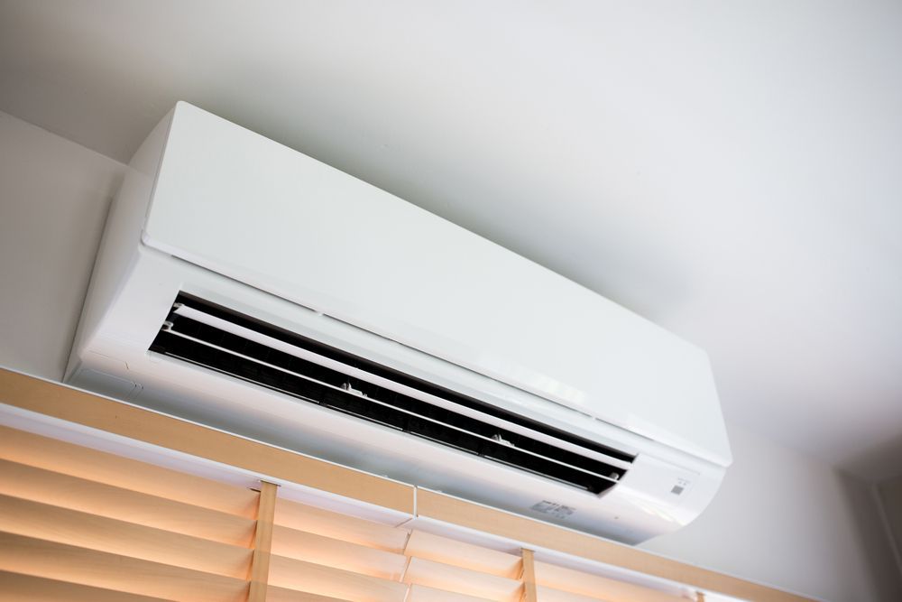 White Wall-mounted Air Conditioning Unit Above Wooden Blinds — M.R. Services Air Conditioning Pty Ltd In Taminda, NSW
