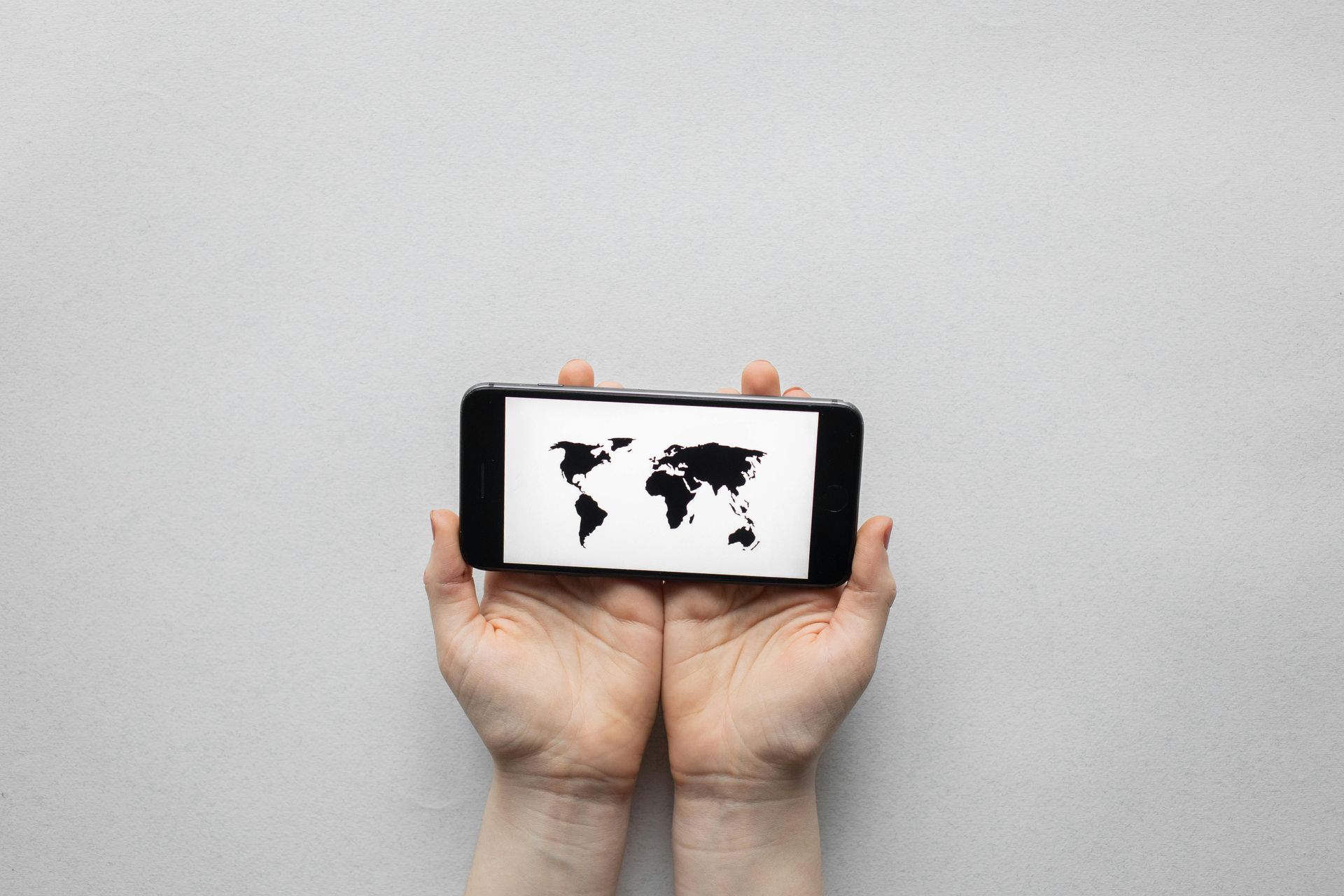 Woman in green top smiling, holding a white tube of skincare.