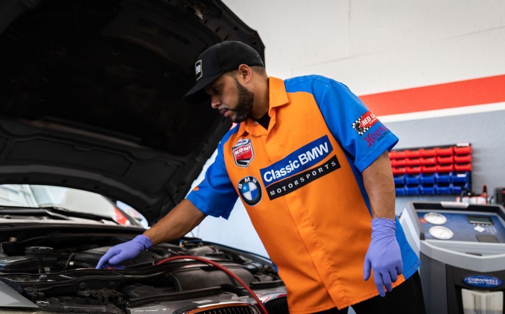 A man is working on a bmw in a garage.